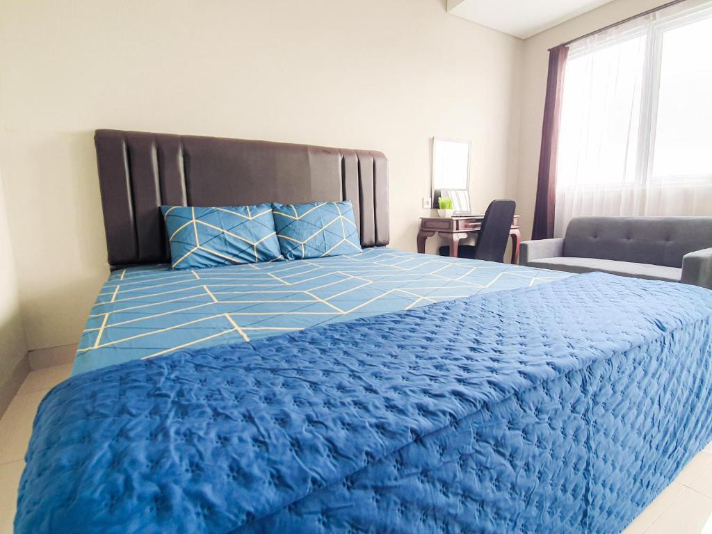 a bedroom with a blue bed with a blue comforter at Royal Sentul Al Alami in Kedungmanggu
