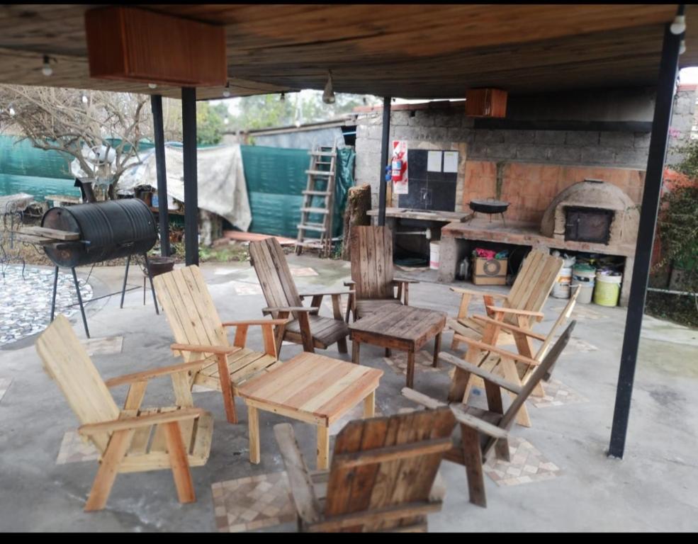 a group of wooden chairs and a table and a grill at La Galactica in Salta