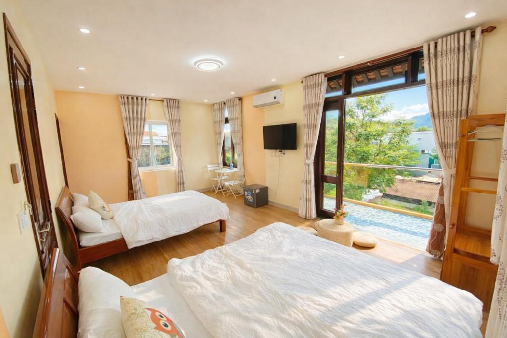 a hotel room with two beds and a large window at PU Homestay in Hue