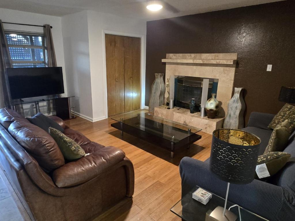 a living room with two couches and a fireplace at Sunshine village in Euless