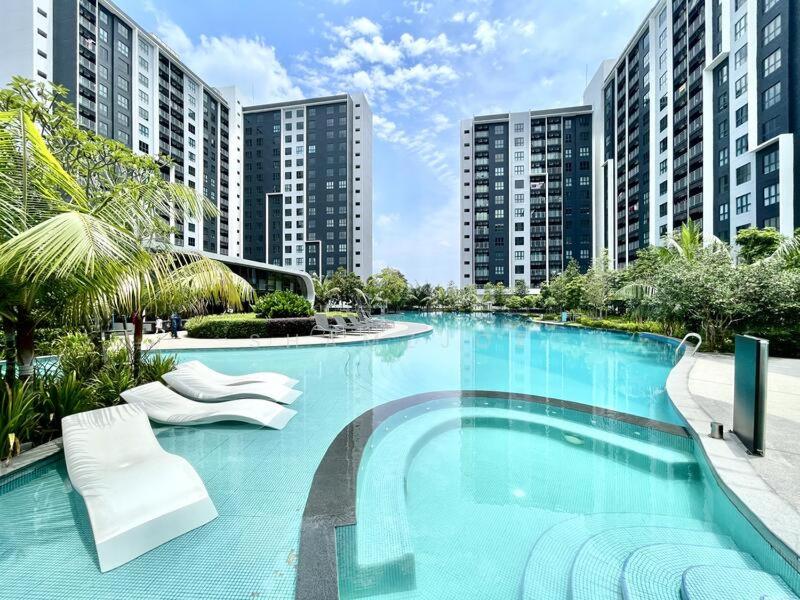 a large swimming pool with white chairs and buildings at Aisy Suite Splash Mania View in Bandar Gamuda Cove