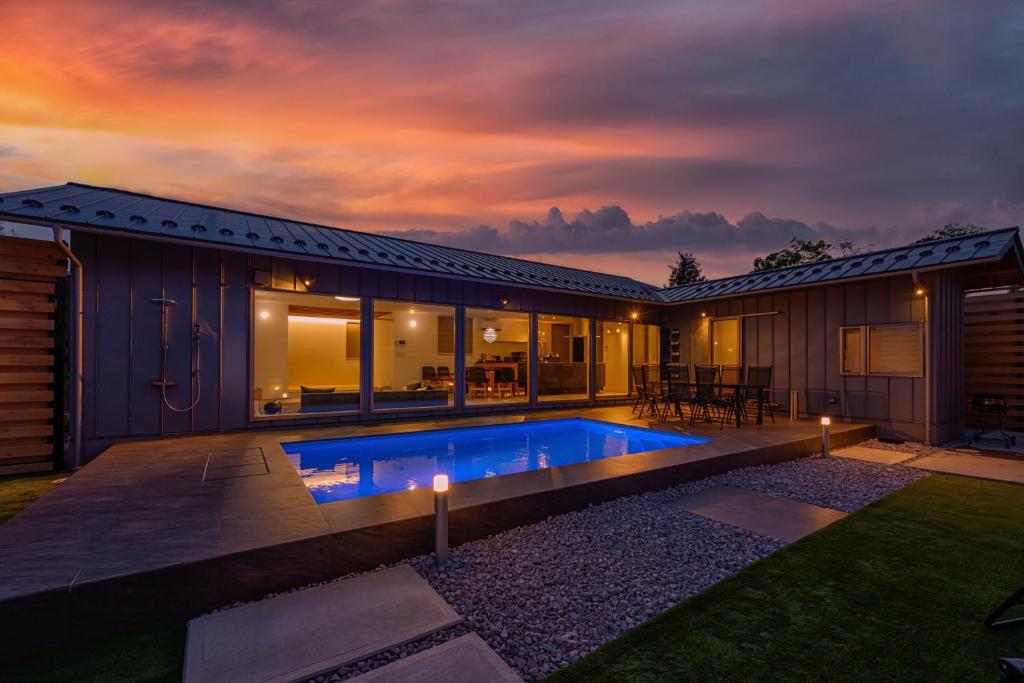 ein Haus mit Swimmingpool im Garten in der Unterkunft HiTOSE in Takashima