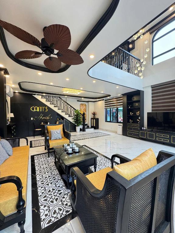 a living room with a ceiling fan and a staircase at Cat Ba Cam's Villa in Cat Ba