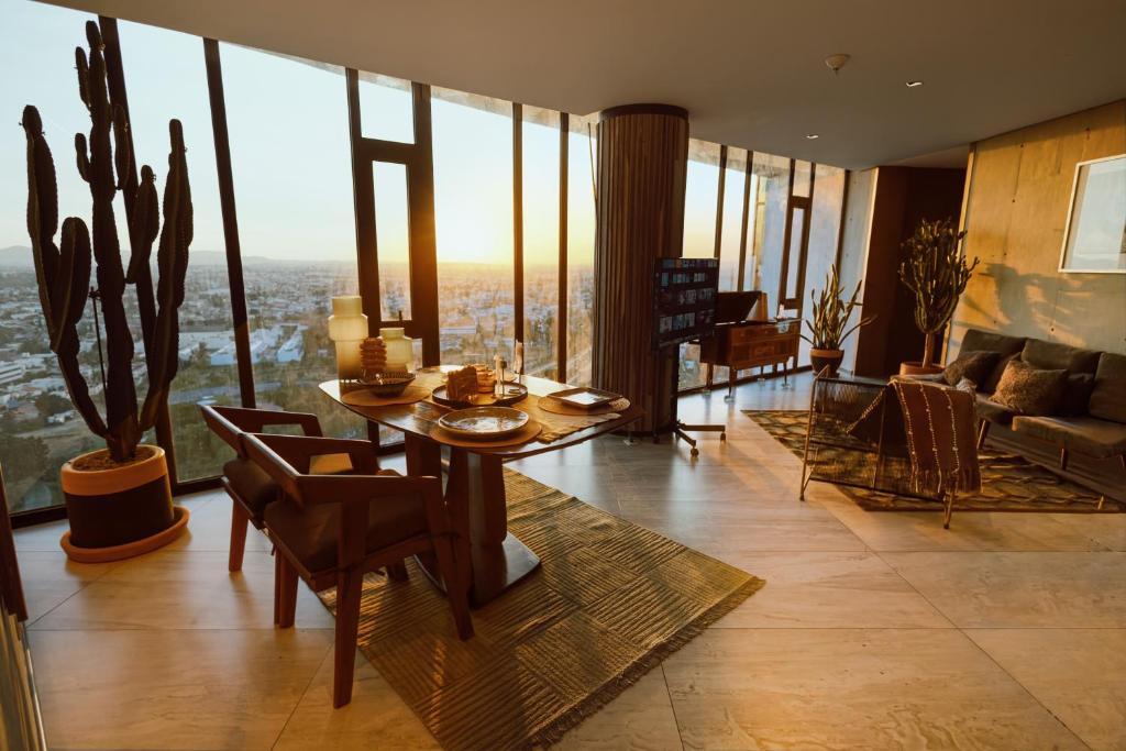 a living room with a table and chairs and a couch at Volcano View Loft, Puebla Skyline1801 in Puebla