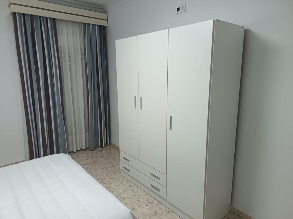 a bedroom with a white wardrobe and a bed at Antonio del Toro in Lora del Río