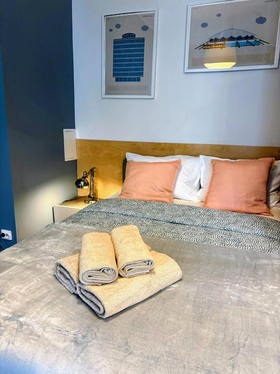 a bed with two towels on top of it at Armonia Old Town in Poznań