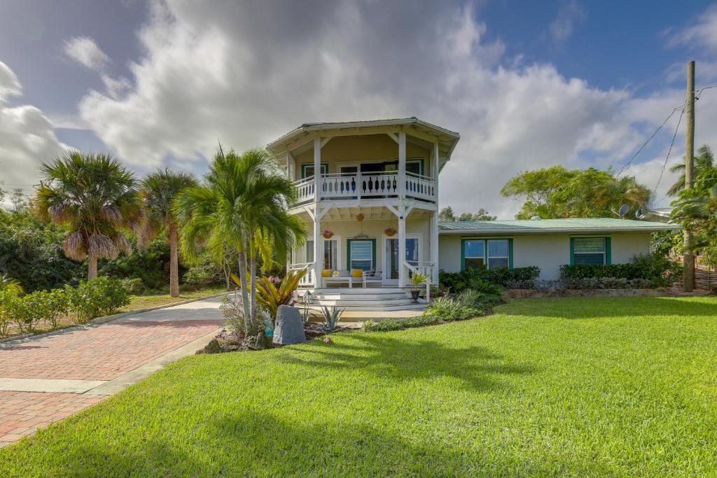 a white house with a porch and a lawn at 3-Acre Retreat, 3 Mi to Dtwn Jensen! Upscale Home in Jensen Beach
