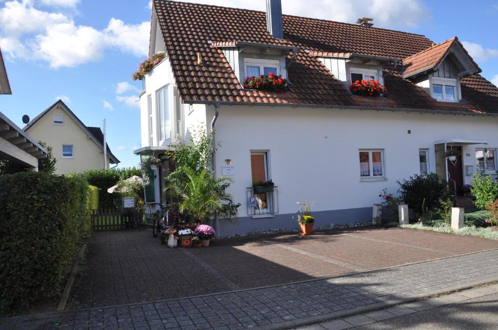 ein weißes Haus mit Blumen an den Fenstern in der Unterkunft DOUBLE Two Lodge in Kappel-Grafenhausen