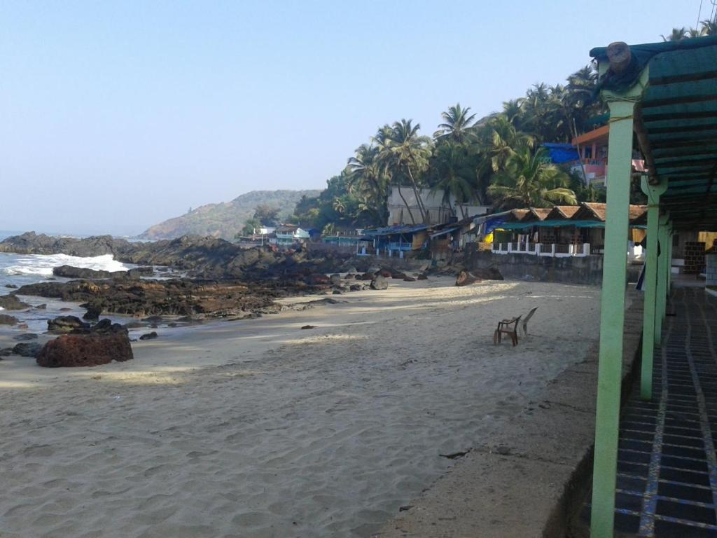 una spiaggia con alcuni edifici e l'oceano di Sea View Cottages ad Arambol