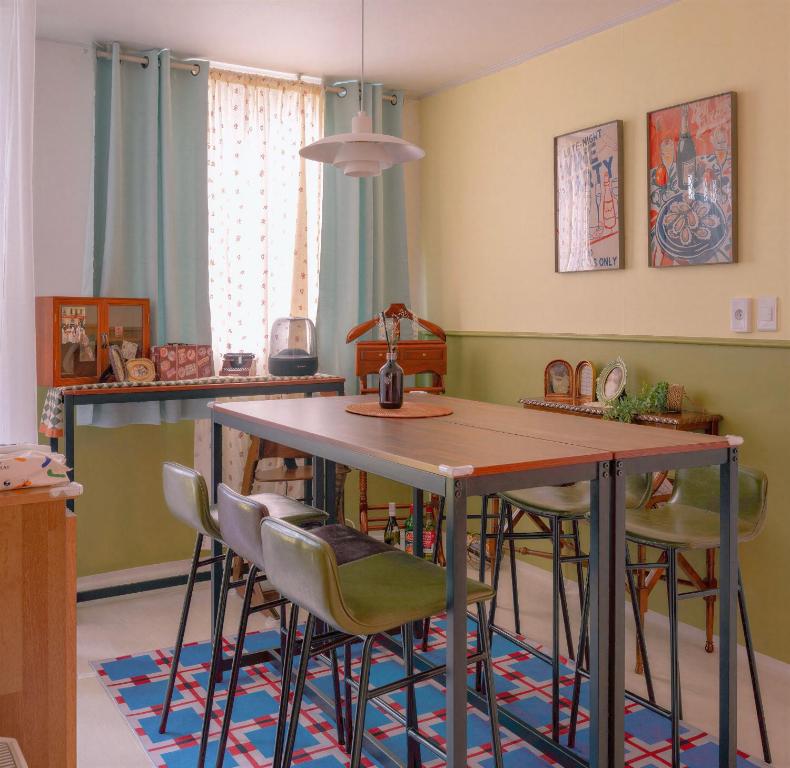 een keuken met een tafel en stoelen bij The Cozy Oven in Busan