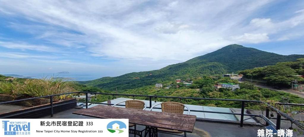 a balcony with a table and a view of a mountain at 雜院-晴海 新北市民宿證號333號 in Jiufen