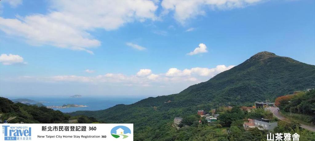 a view of a mountain with the ocean in the background at 山茶雅舍 新北市民宿證號360號 in Jiufen