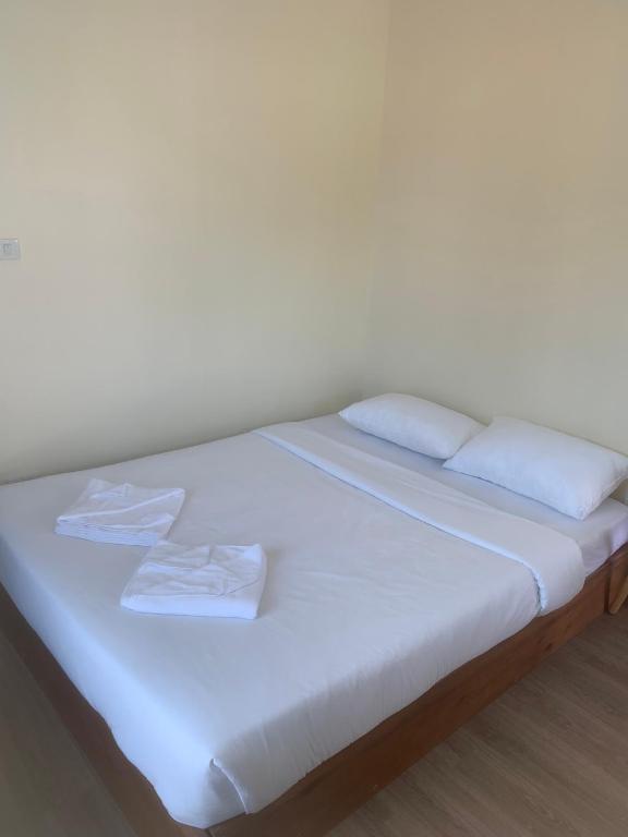 a white bed with white sheets and pillows on it at Nai Yang Guest House in Nai Yang Beach
