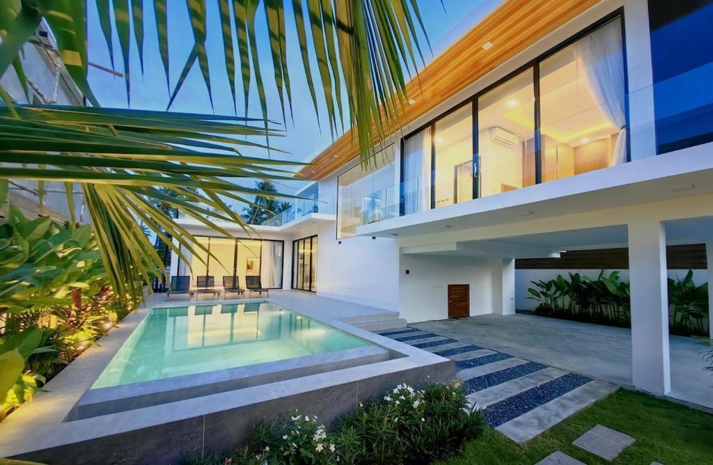 an exterior view of a house with a swimming pool at Tropical Luxury Samui Villa Donava in Nathon Bay