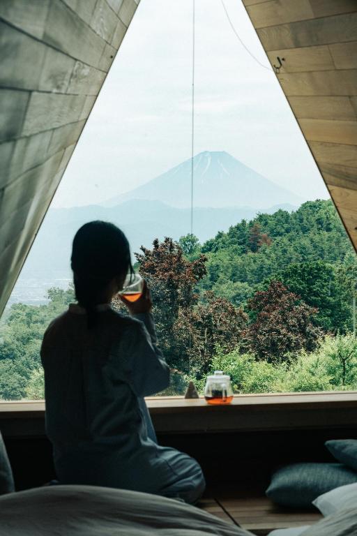 a woman looking out a window at a mountain at ALPS LAPS withTENAR in Kami-iino