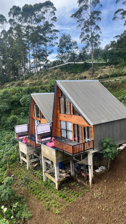 a house sitting on top of a wooden platform at Padangsari Cabin House in Diyeng