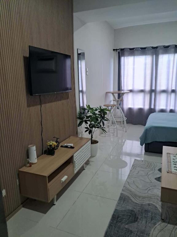 a living room with a television on a wall at Athenas Cozy Place in Mandaue City