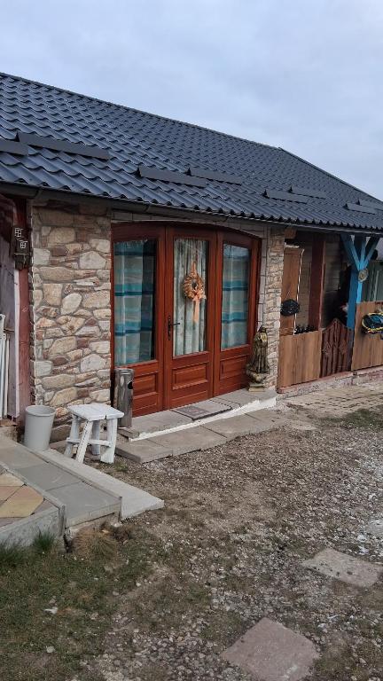 een huis met een houten deur en een bank voor de deur bij ARIANA home in Turda