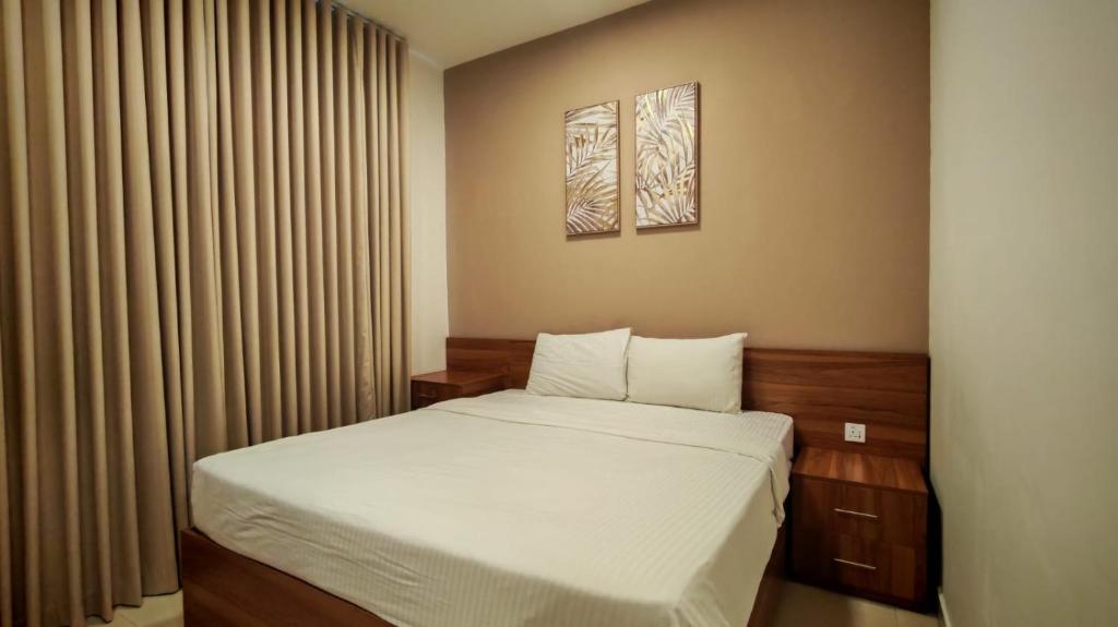 een kleine slaapkamer met een bed met witte lakens bij Al Khaleej Plaza Furnished Hotel Apartments in Ajman 