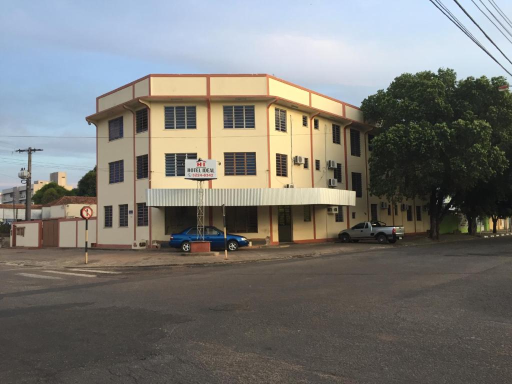 un edificio con un coche azul estacionado frente a él en Hotel Ideal, en Boa Vista