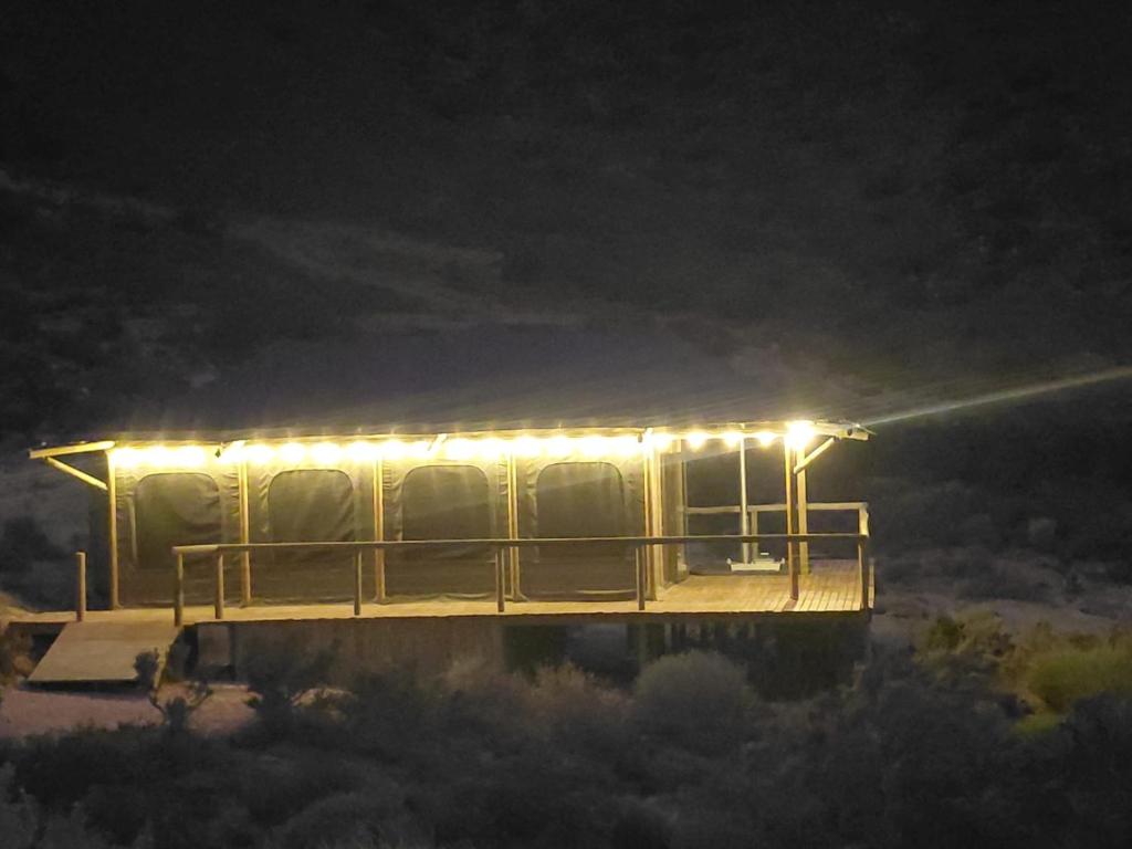 a house with lights on top of it at night at Oudemuur Glamping in Montagu