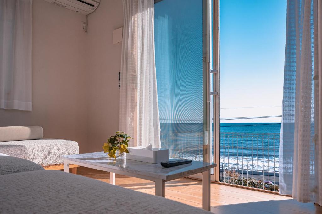 een woonkamer met uitzicht op de oceaan bij 波音ハウス in Yugawara