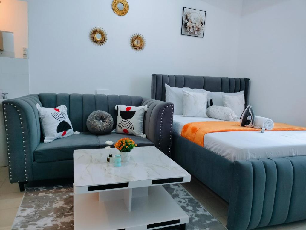 a living room with a couch and a bed at Cutie Coastal Studio in Mombasa