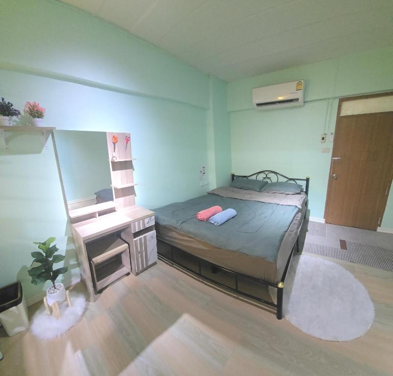 a bedroom with a bed and a desk in it at 103 Lovely AC apartment with private kitchen in Bangkok