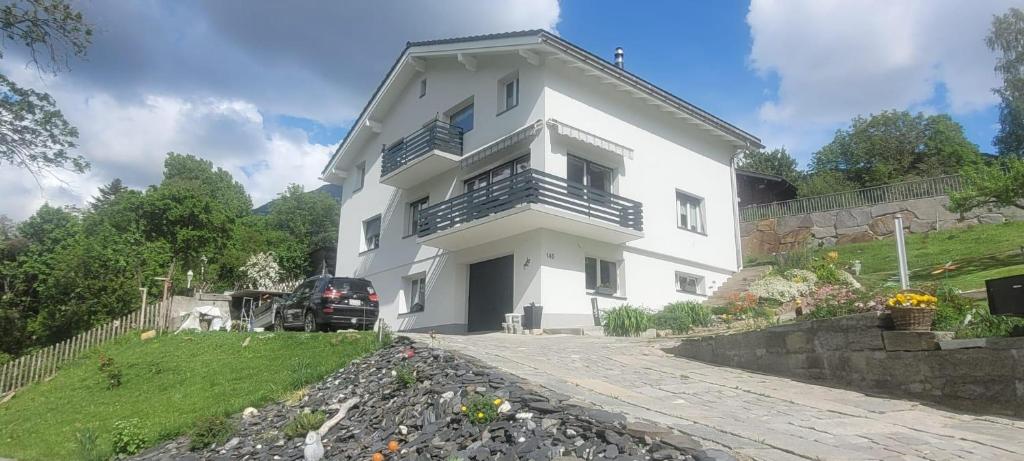 a white house with a car parked in front of it at Ferienwohnung Stützen in Brig