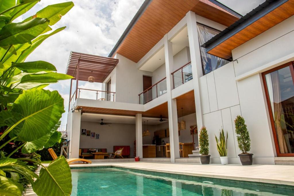a house with a swimming pool in front of it at Rumah Melissa - Modern Boho 3BR Brand New Villa in Sanur in Sanur