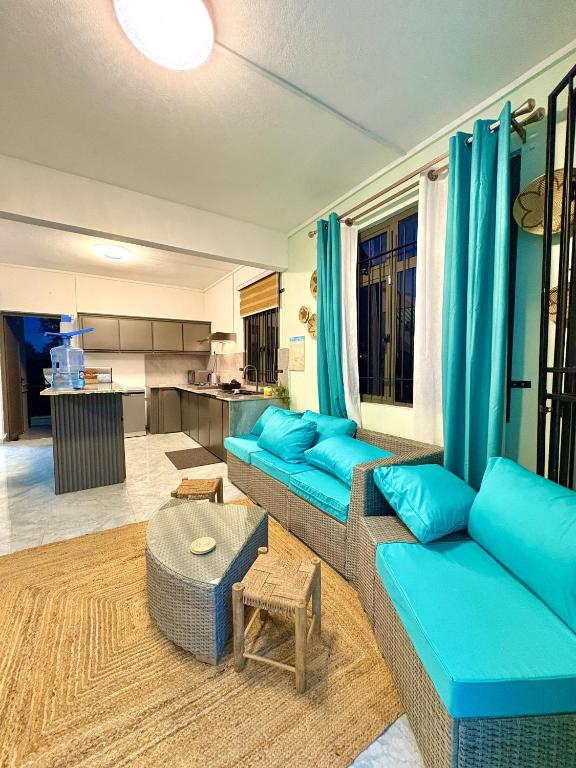 a living room with blue couches and a kitchen at Salmaan Villa in Grand-Baie