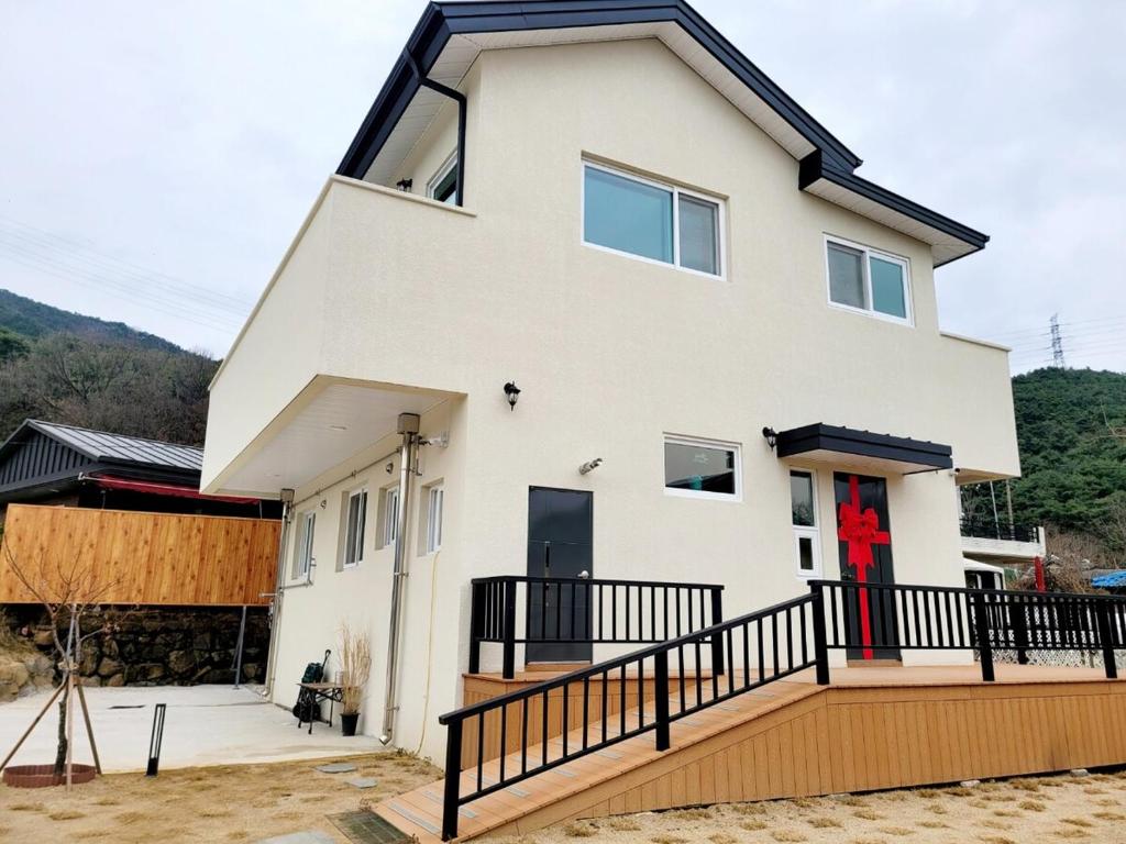 a large white house with a black railing at Vong Stay 봉스테이 in Chilgok