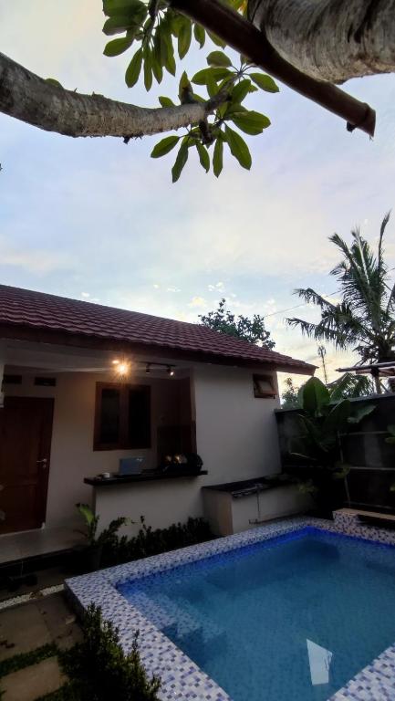 a villa with a swimming pool in front of a house at D 'Jambon Escape in Yogyakarta