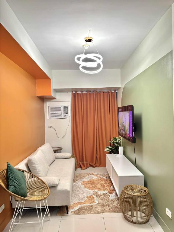 a living room with a couch and a tv at NM 1BR Condo with Balcony at Horizons 101 in Cebu City