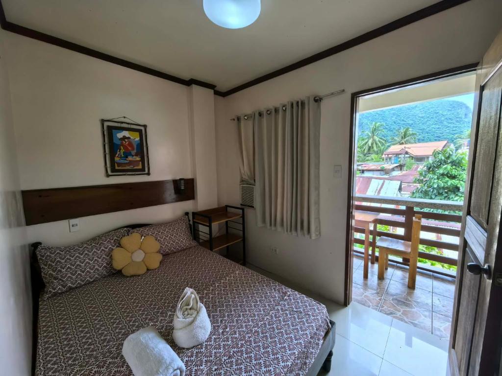 een slaapkamer met een bed en een grote glazen schuifdeur bij SILVERISE Pension in El Nido