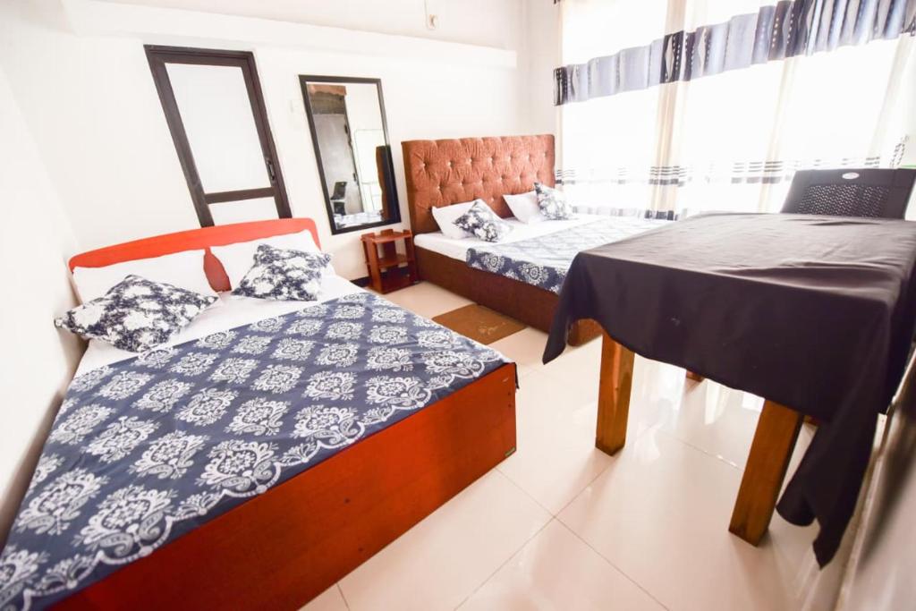 a room with two beds and a laptop on a table at Bricks Bungalow in Ratnapura