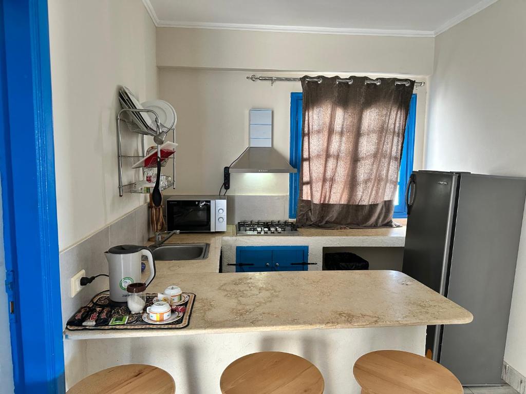 a small kitchen with a counter and a refrigerator at Amnesia Residence in Naama Bay - Downtown in Sharm El Sheikh