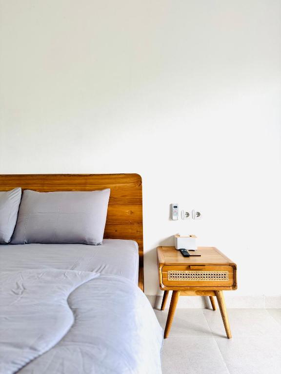 a bedroom with two beds and a nightstand next to a bed at Chevana House Jimbaran in Jimbaran