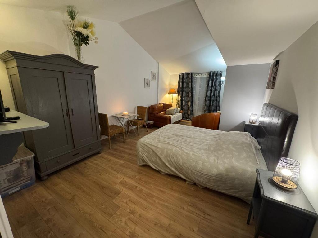 een slaapkamer met een bed en een woonkamer bij L'olivier TESSA Hôtesse suite 30m2 terrasse 20m2 in La Celle