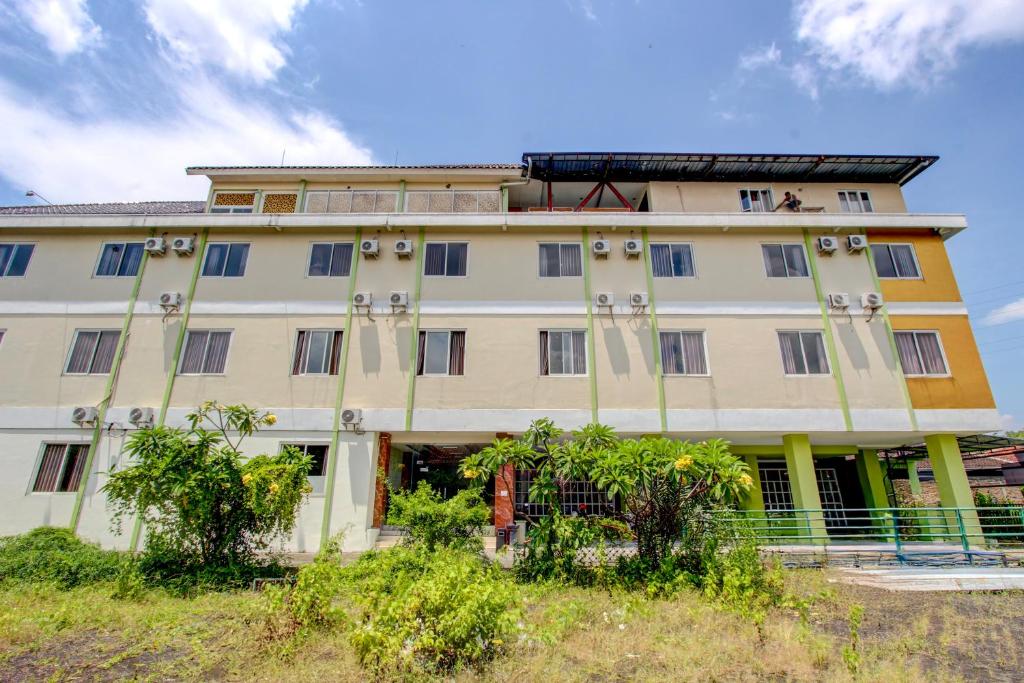 a large building with trees in front of it at Collection O near Stadion Manahan formerly Graha Laweyan Solo in Bonorejo
