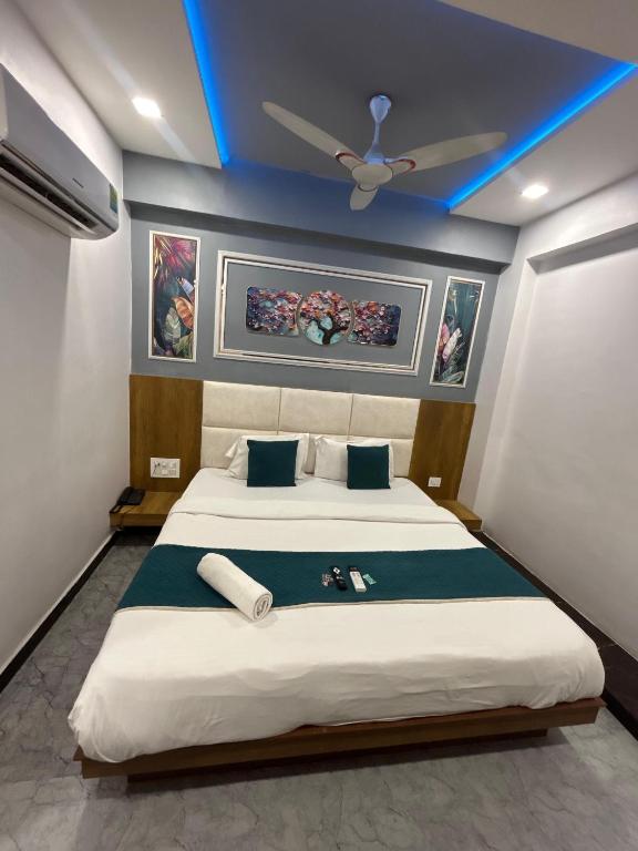 a bedroom with a large bed with a ceiling fan at Hotel secure inn saroli in Surat