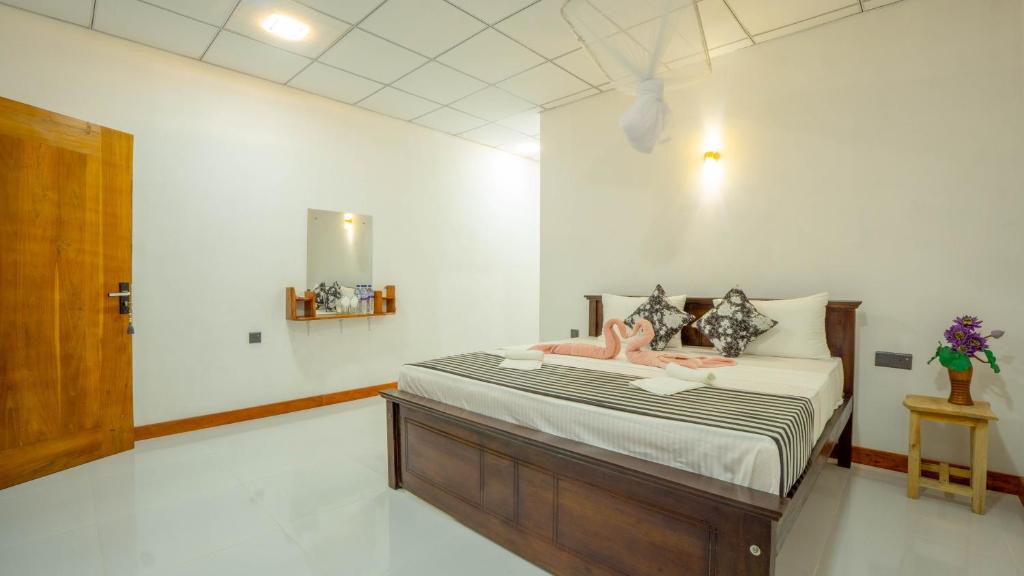 a bedroom with a bed with pink dolls on it at Isuru Homestay Pidurangala in Sigiriya