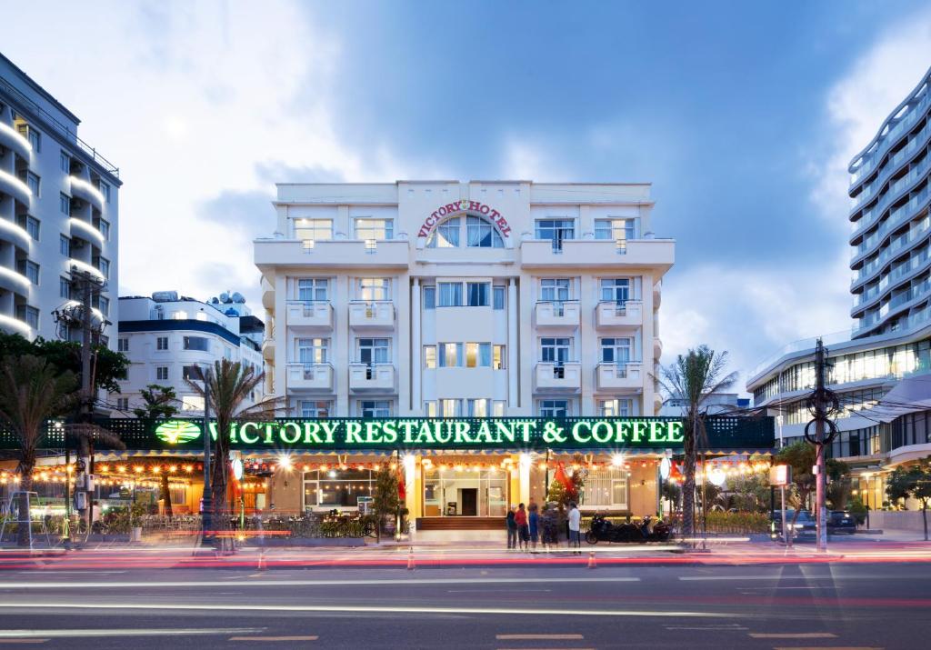 a large white building with a sign in front of it at Victory Hotel Old Wing in Vung Tau