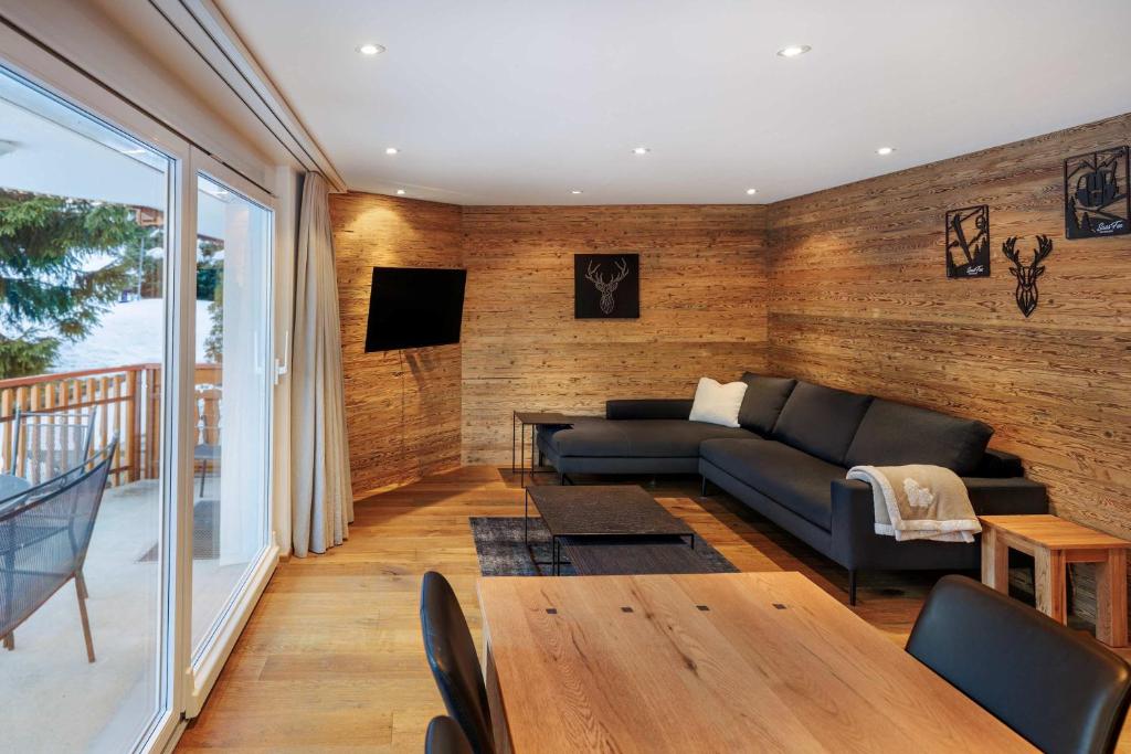 a living room with a couch and a table at Cornelia 1 Ski-In-Out Stunning Views & Sleeps 8 in Saas-Fee