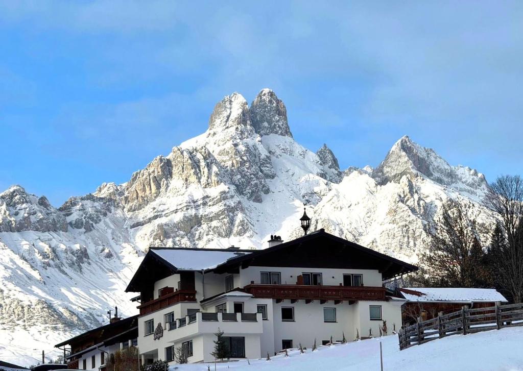 een gebouw voor een met sneeuw bedekte berg bij Haus Bergfried in Filzmoos