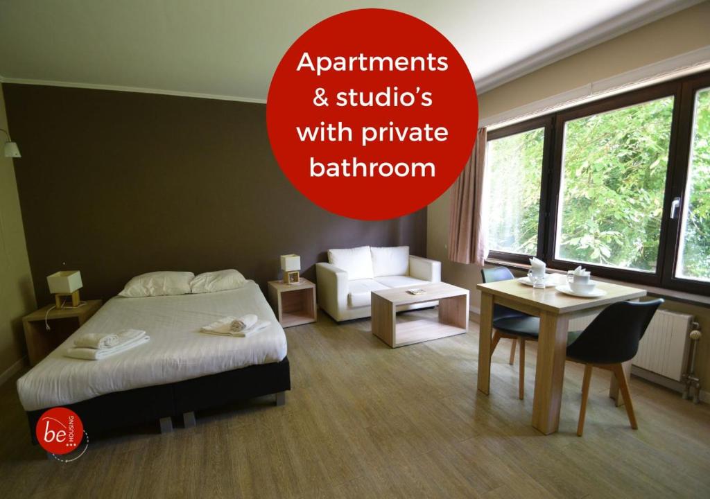 a bedroom with a bed and a table and a chair at Budget Flats Brussels in Brussels