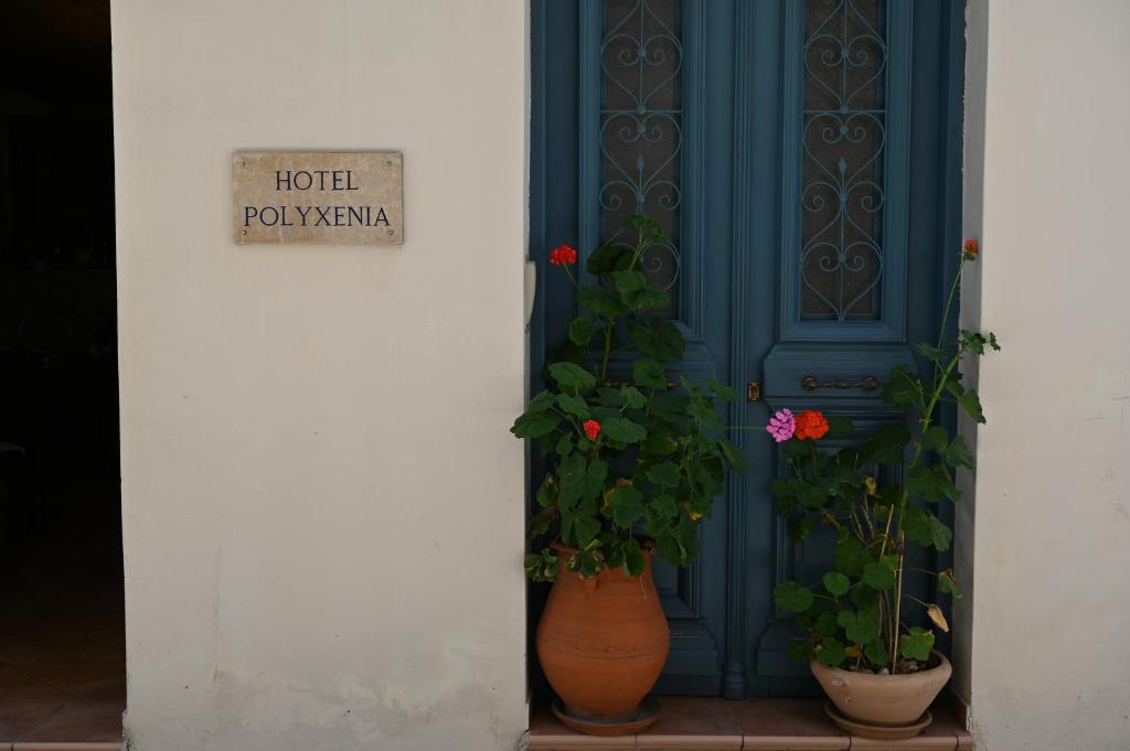 een blauwe deur met twee potplanten ervoor bij Polyxenia Hotel in Nafplio