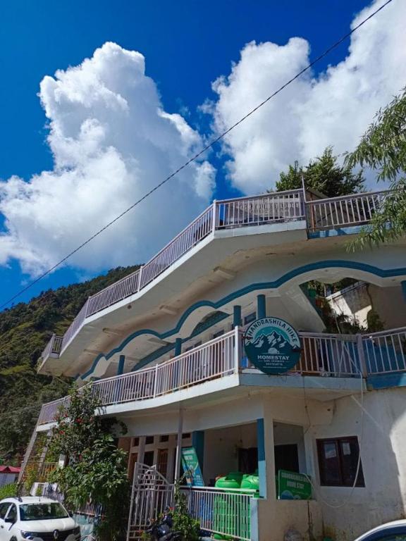 a building with a balcony on top of it at Chandarshila hike homestay in Ukhimath