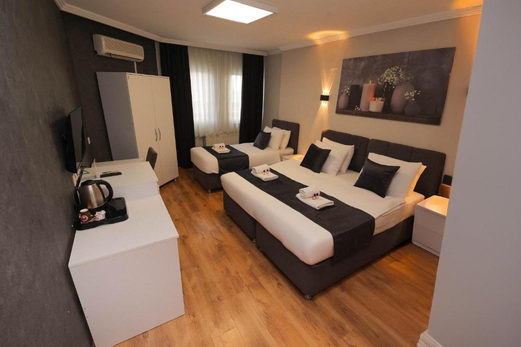 a hotel room with a large bed and a couch at Özdemir Inn Otel in Balıkesir