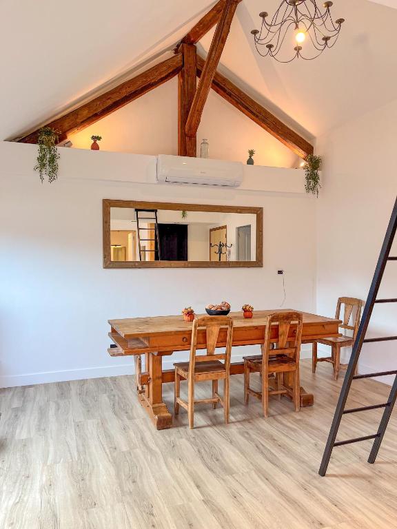 a dining room with a wooden table and chairs at Cocon sous les toits in Albertville
